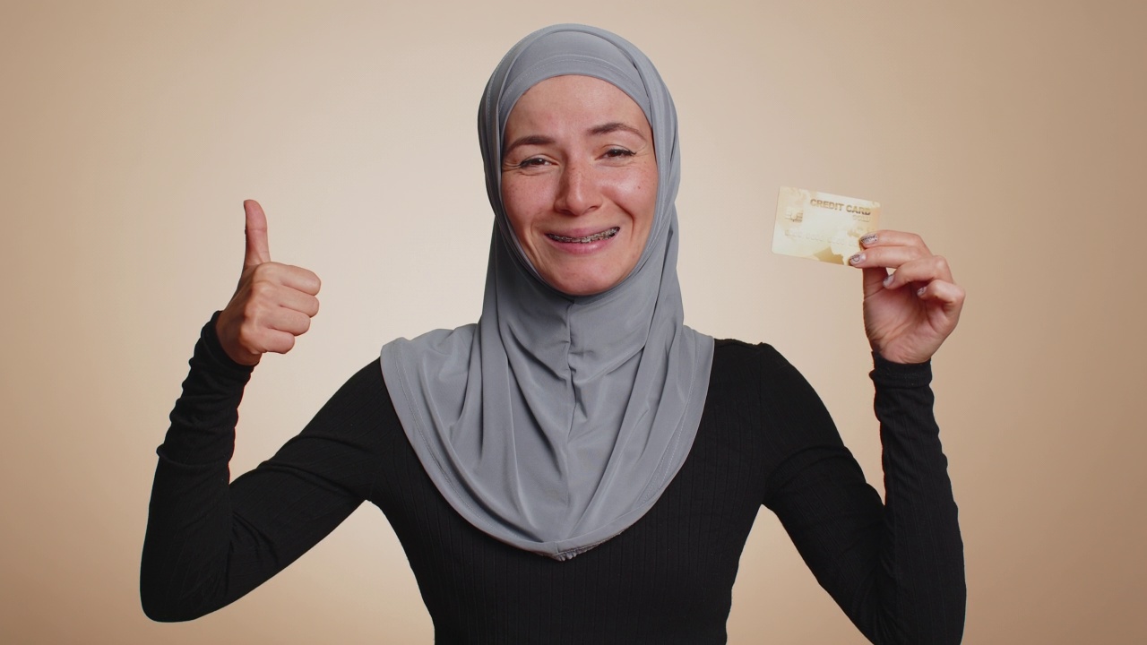 快乐的女子展示塑料信用卡的广告无现金转账，网上购物视频素材