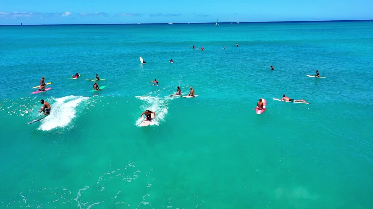 航拍的男人和女人在阳光明媚的假期在海上冲浪-怀基基，夏威夷视频下载