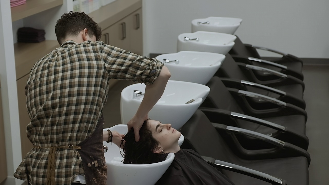 发型师为女性客户进行头皮按摩视频下载