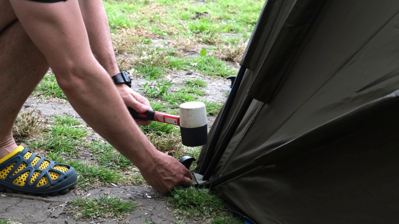一个人在露营旅行中搭建帐篷。河边的钓鱼帐篷视频下载