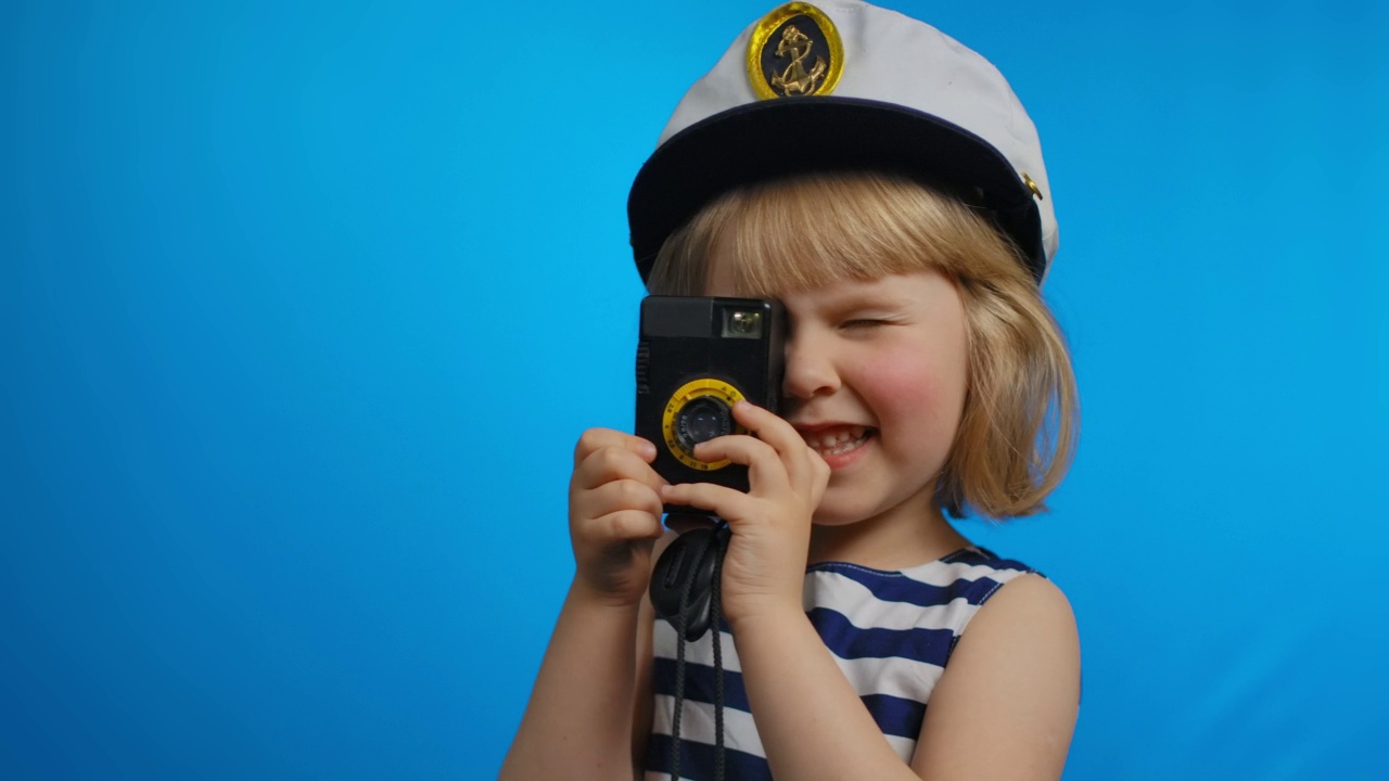 戴着水手帽的可爱小女孩正在用复古相机拍照视频下载