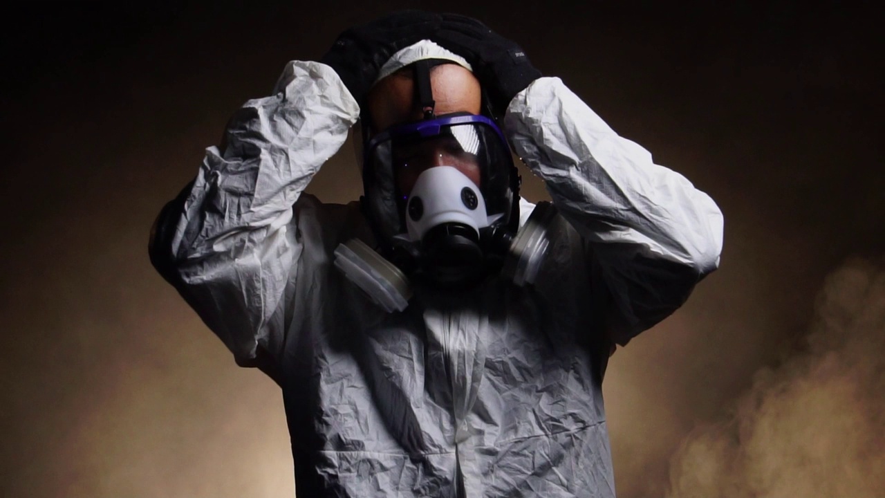 穿着防护服和防毒面具的男子站在雾中视频下载