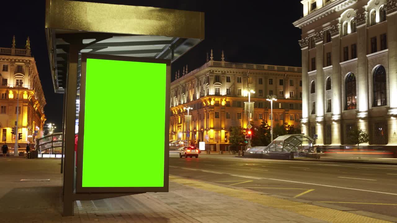 夜间公共汽车站的彩色绿色屏幕广告牌。视频素材