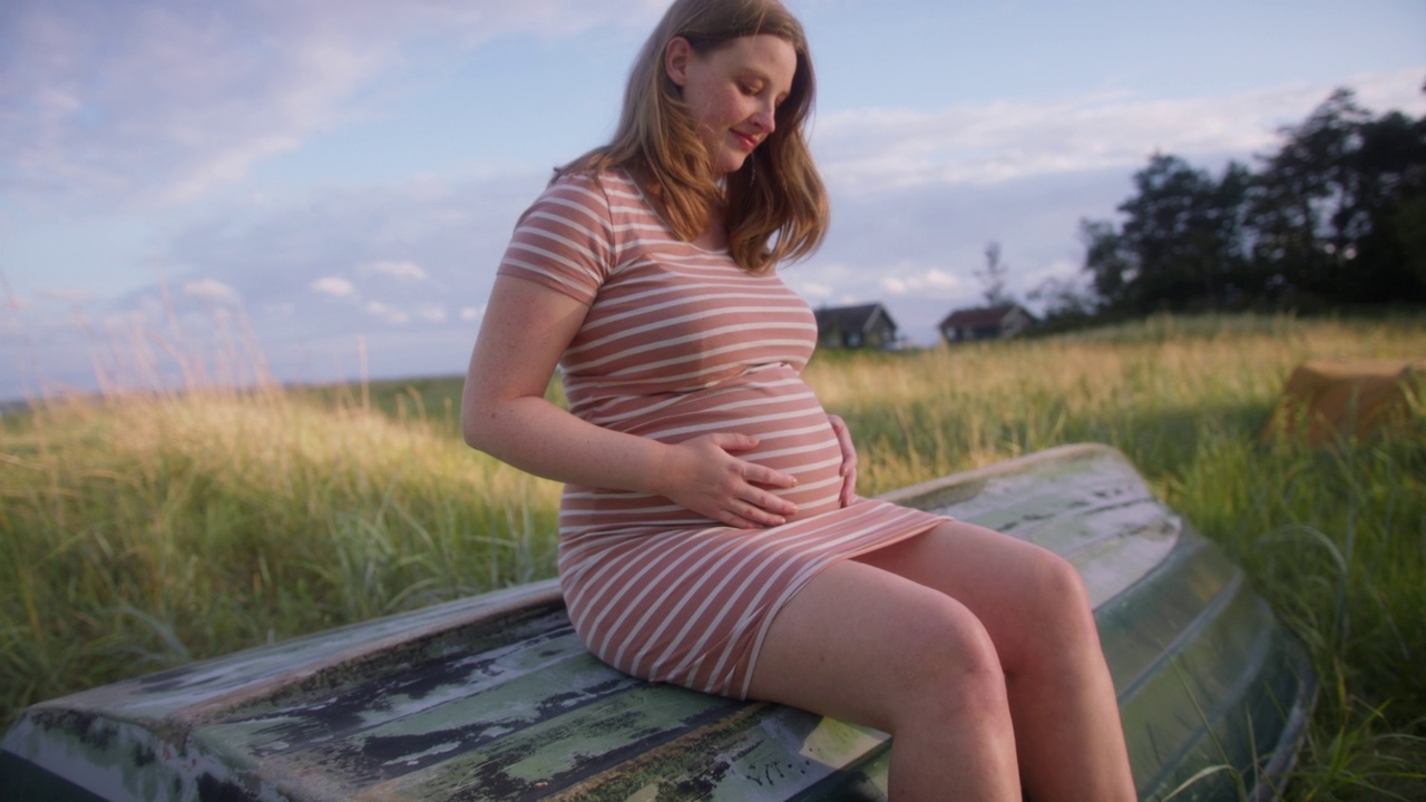 孕妇坐在树干长椅上视频下载