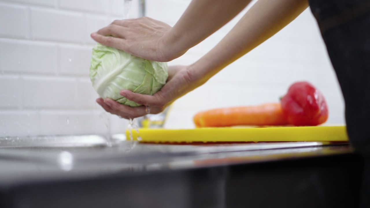 一名妇女用手清洗菜单沙拉的蔬菜视频素材