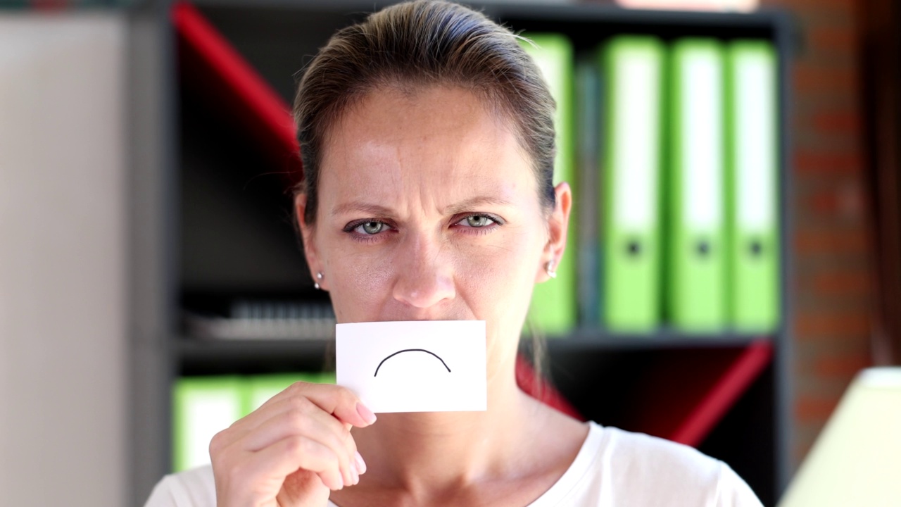 悲伤的女人带纸到她的嘴唇画悲伤的微笑4k电影慢动作视频下载