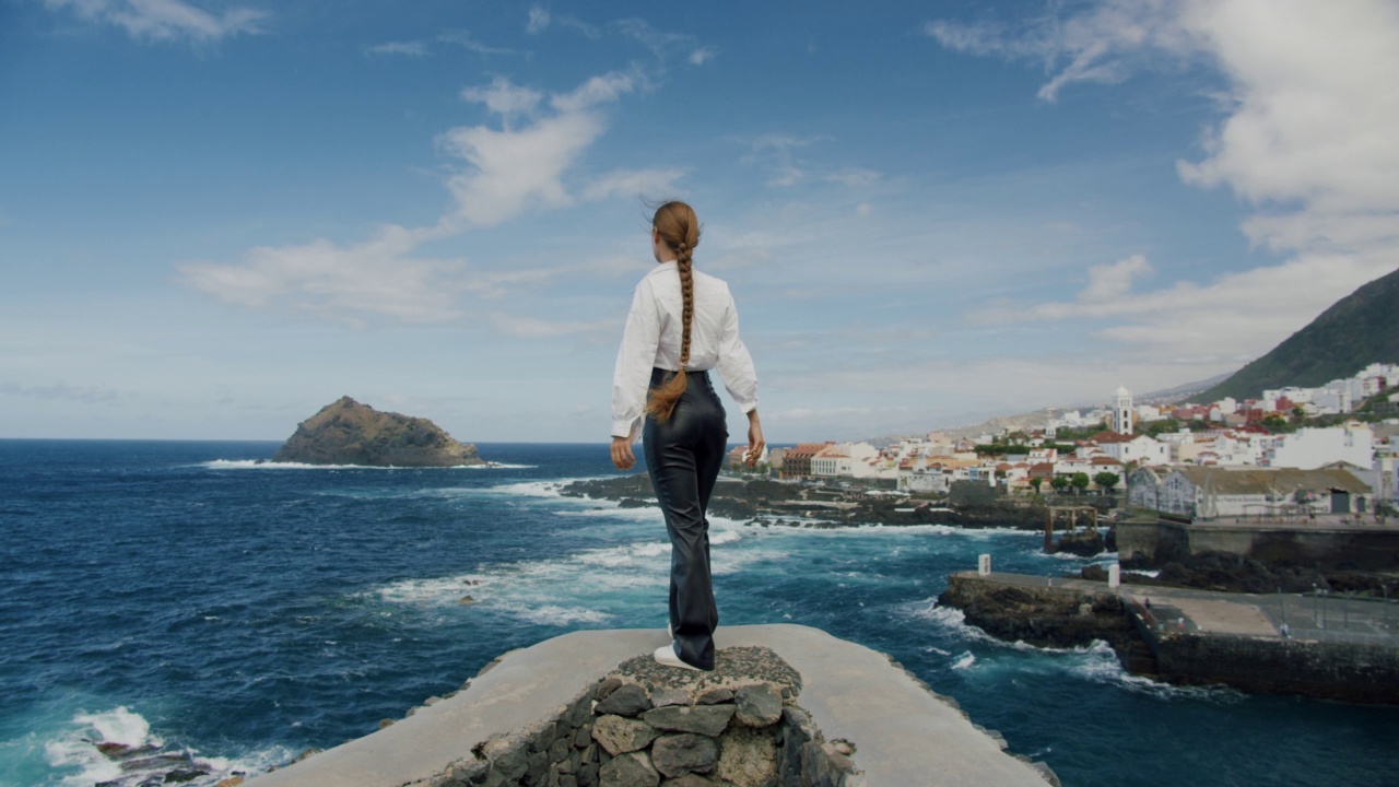 后景一个长发女人站在大海前面的边缘。Gorachico。特内里费岛视频素材
