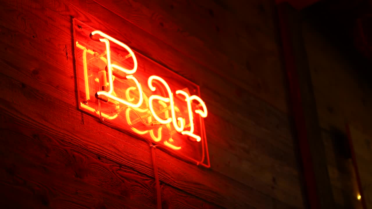 酒吧荧光灯招牌上的商业入口在红色的木质表面广告业务在手持移动视频下载