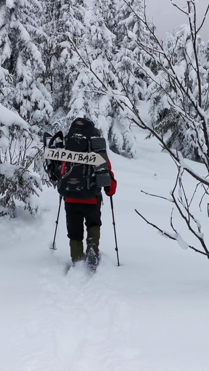 一个背着背包的男人在冬天徒步旅行。他的背包上有个牌子写着巴拉圭视频下载