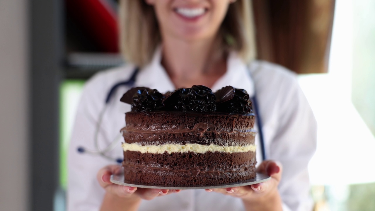 医生或护士在诊所拿着巧克力蛋糕视频下载