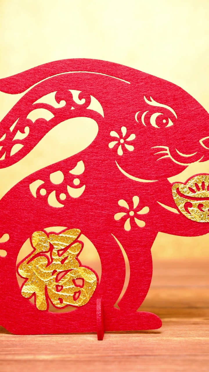 pan view中国新年兔子吉祥物剪纸在黄金背景在垂直组成的汉字意味着财富没有标识没有商标视频素材