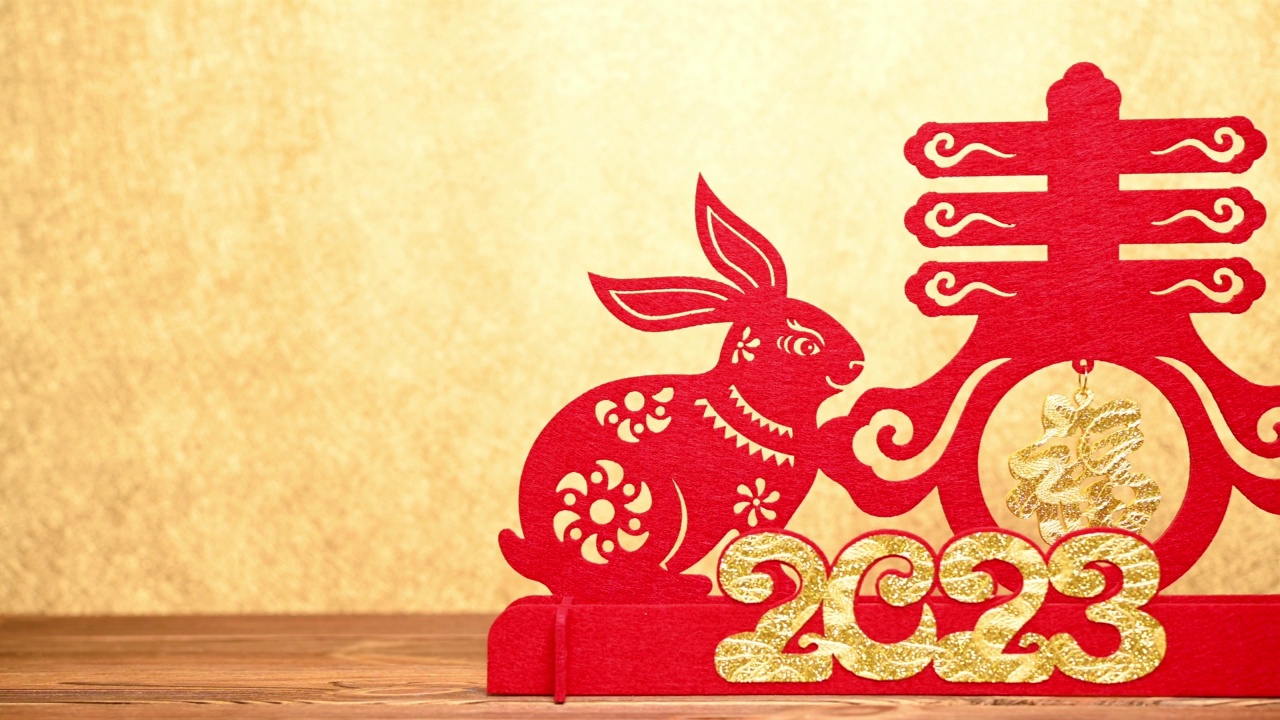 pan view中国新年兔子吉祥物剪纸与红色口袋在黄金背景在水平组成的汉字意味着财富和春天没有标识没有商标视频素材