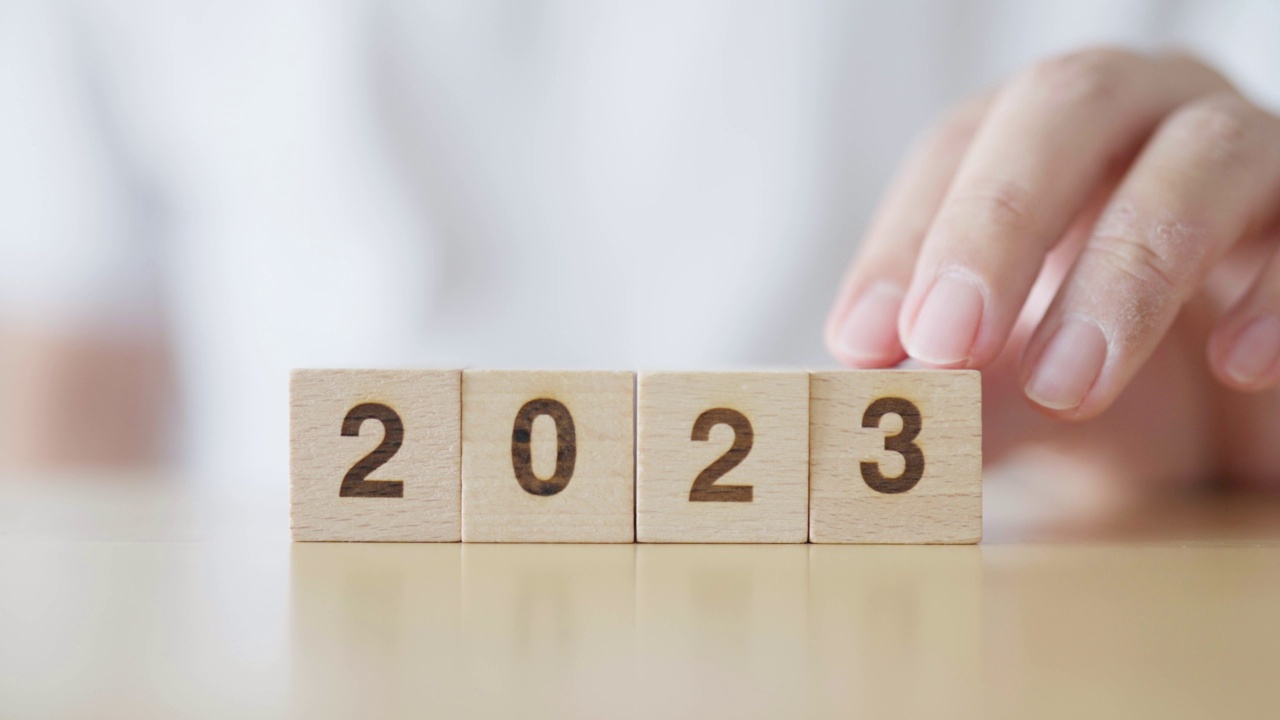 2022年新年改为2023年。手放有年份编号的木块。新年立志，圣诞快乐视频下载