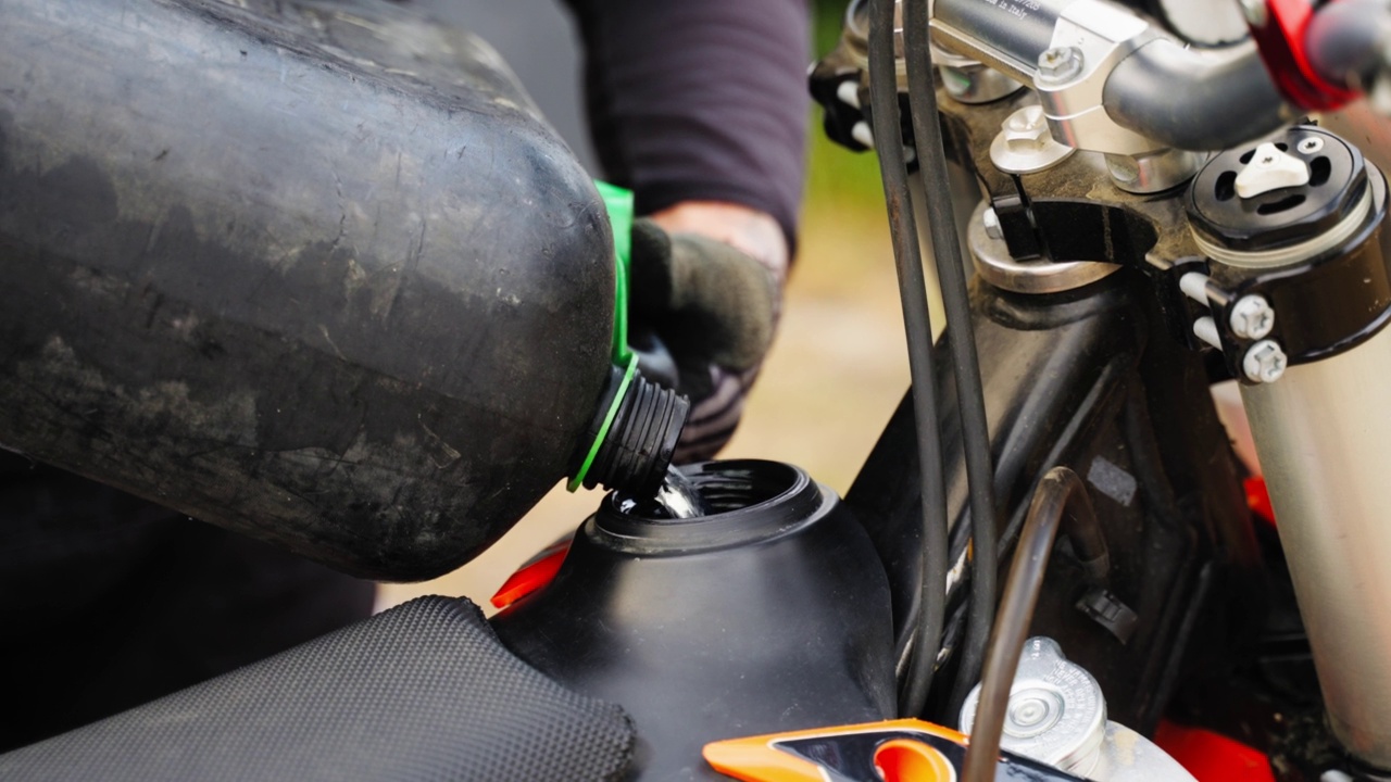 特写一个人的手倒汽油在摩托车越野赛坦克视频下载