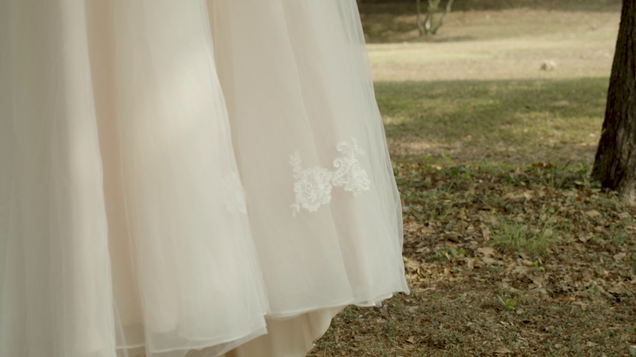 白色的婚纱挂在挂在花园里树上的衣架上视频素材