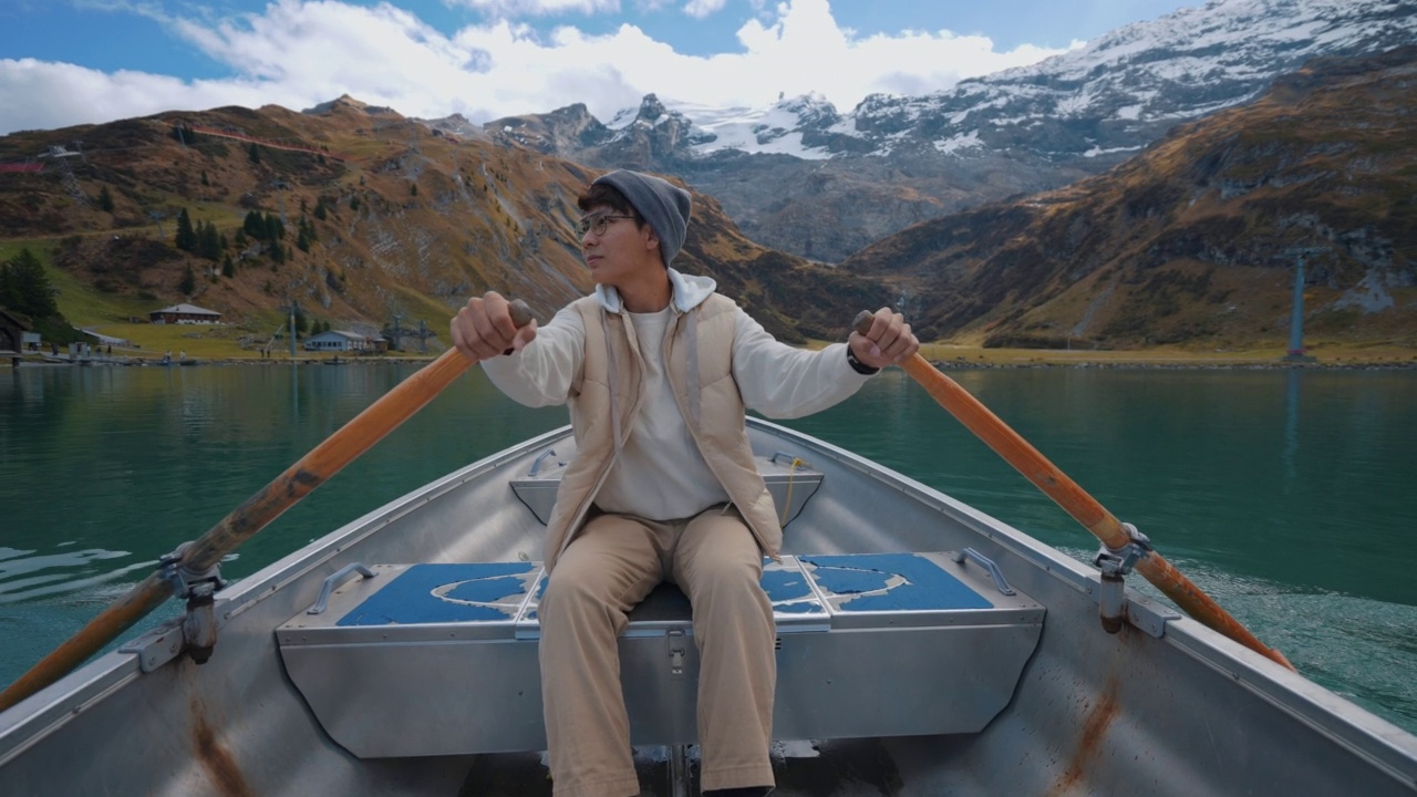 亚洲男子在湖中划船视频素材