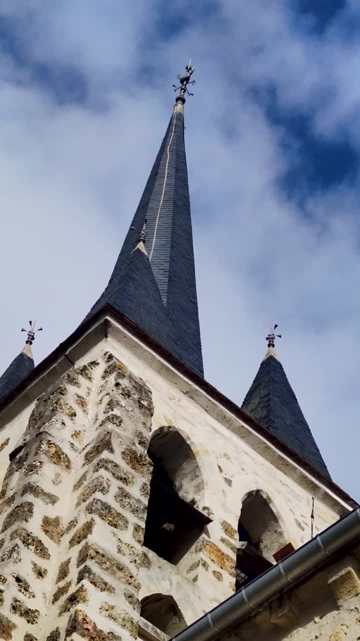 夏日天空背景下的传统建筑风格的教堂和尖塔。法国巴黎，蓝天白云映衬下的教堂尖塔视频下载