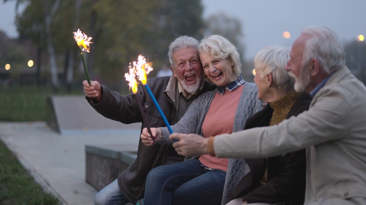 一群兴高采烈的老人在大自然中玩着燃烧的火把。视频素材