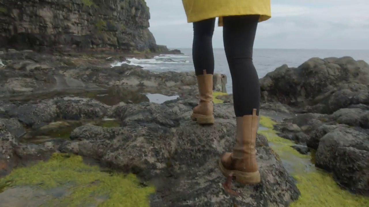 一个女人的脚在法罗群岛的岩石上行走的镜头视频下载