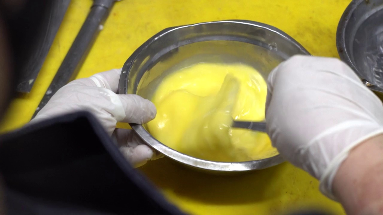 男人戴着手套，用慢动作打鸡蛋，做炒鸡蛋。视频下载
