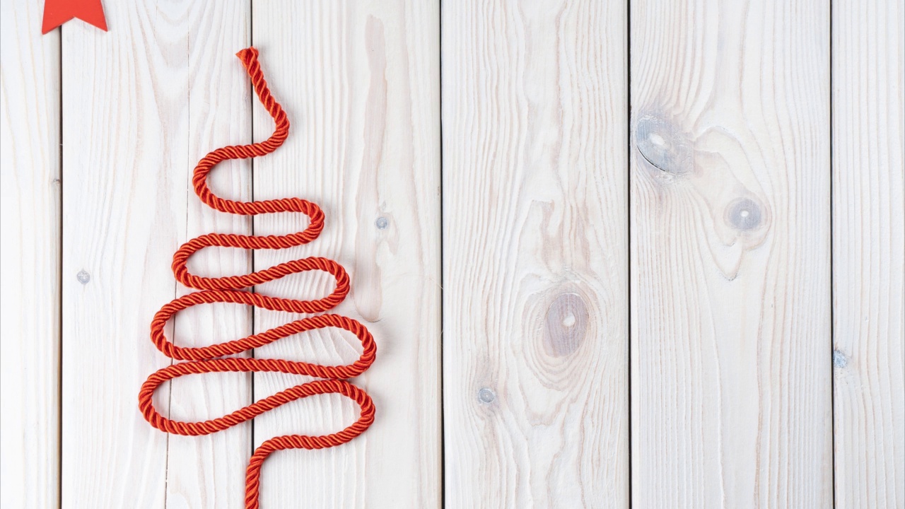 循环视频的红绳折叠成圣诞树的形状与星星，白色的木质表面。副本的空间。圣诞快乐视频下载
