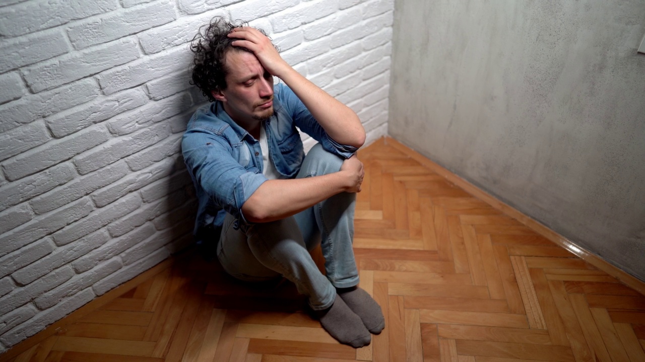情绪崩溃的男人独自坐在地板上视频下载