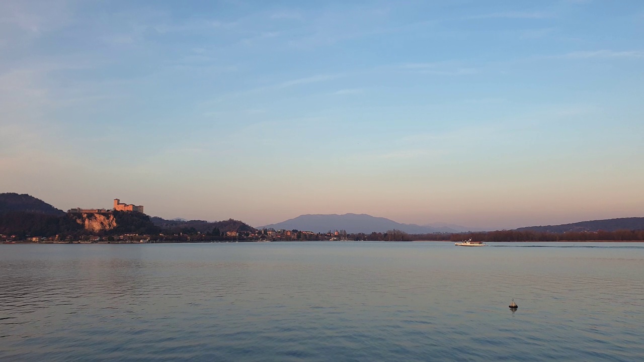 渡船在夕阳下驶过马乔雷湖，背景是安杰拉要塞。静态的照片视频素材