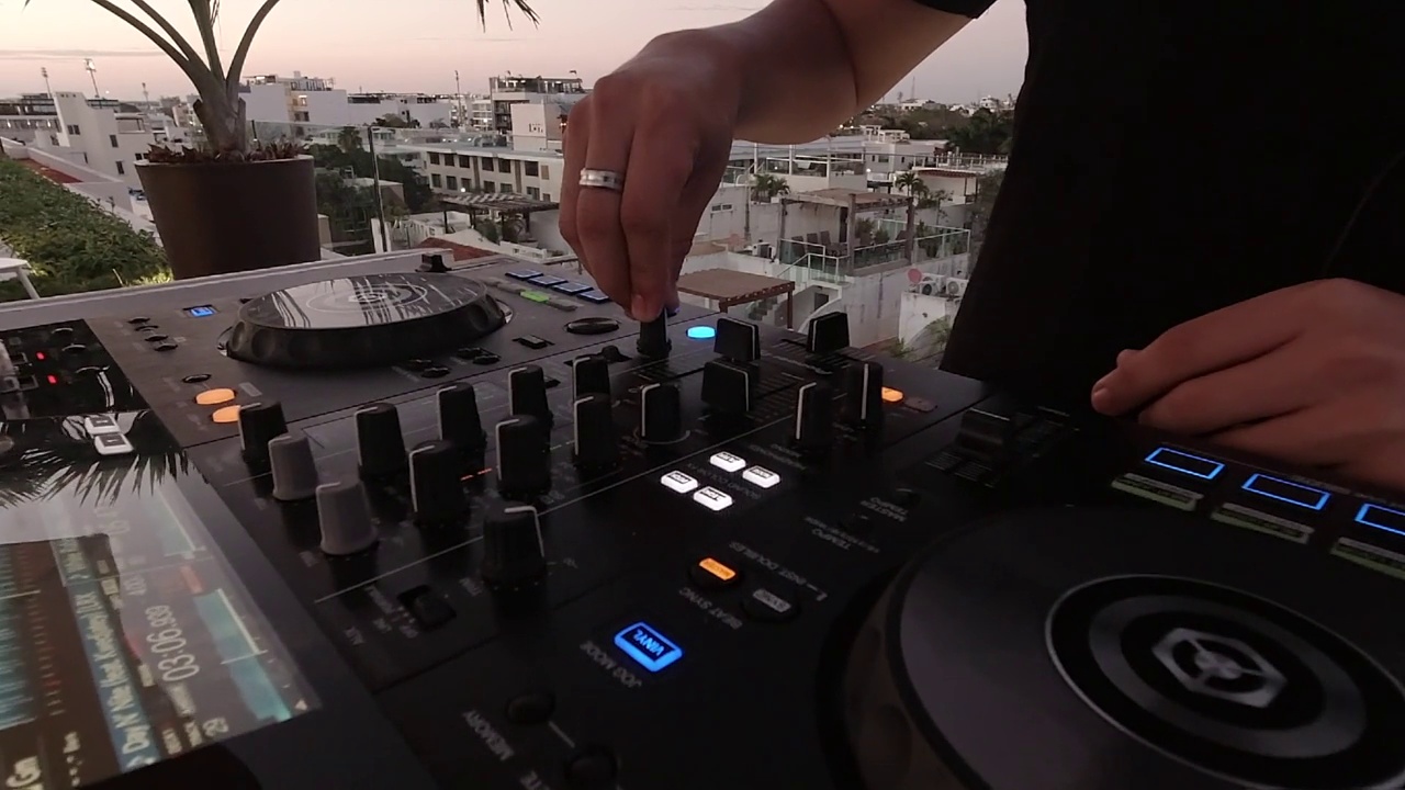 在日落的时候，DJ的手在建筑物的顶部混音视频下载