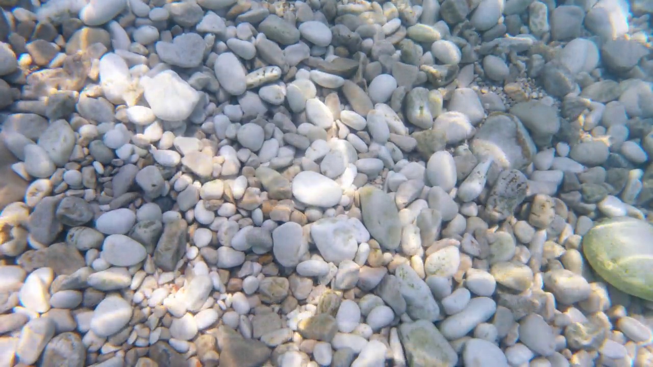 俯视图的阳光反射在清澈的湖水与石头视频下载