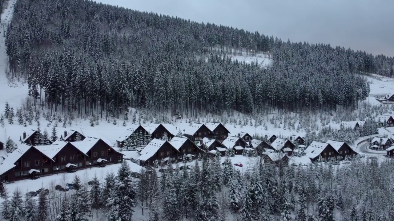 视频在乌克兰Bukovel滑雪场被雪覆盖的木屋上翻拍视频下载