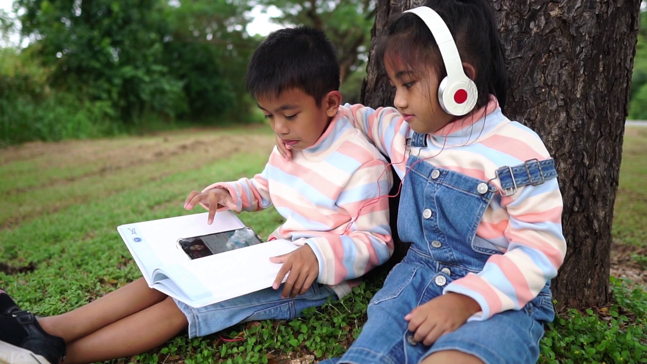 孩子们坐在公园里学习视频素材
