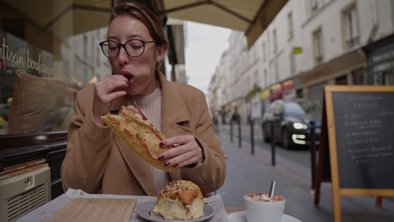 女人，在路边咖啡馆吃三明治喝咖啡视频素材