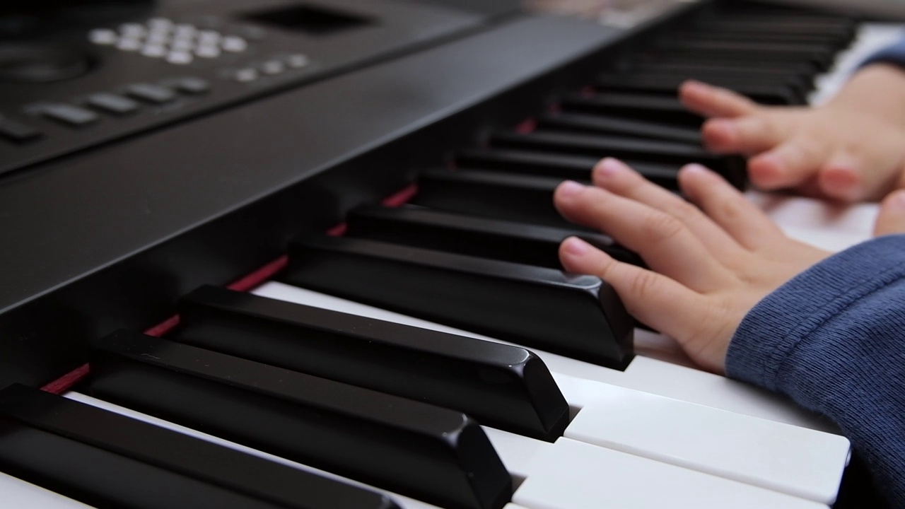 孩子们的手指在钢琴合成器的琴键上弹奏。选择性地专注于钢琴键视频素材