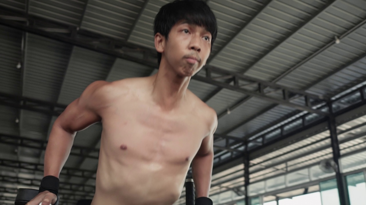亚洲男子在健身房做引体向上时肌肉发达视频下载