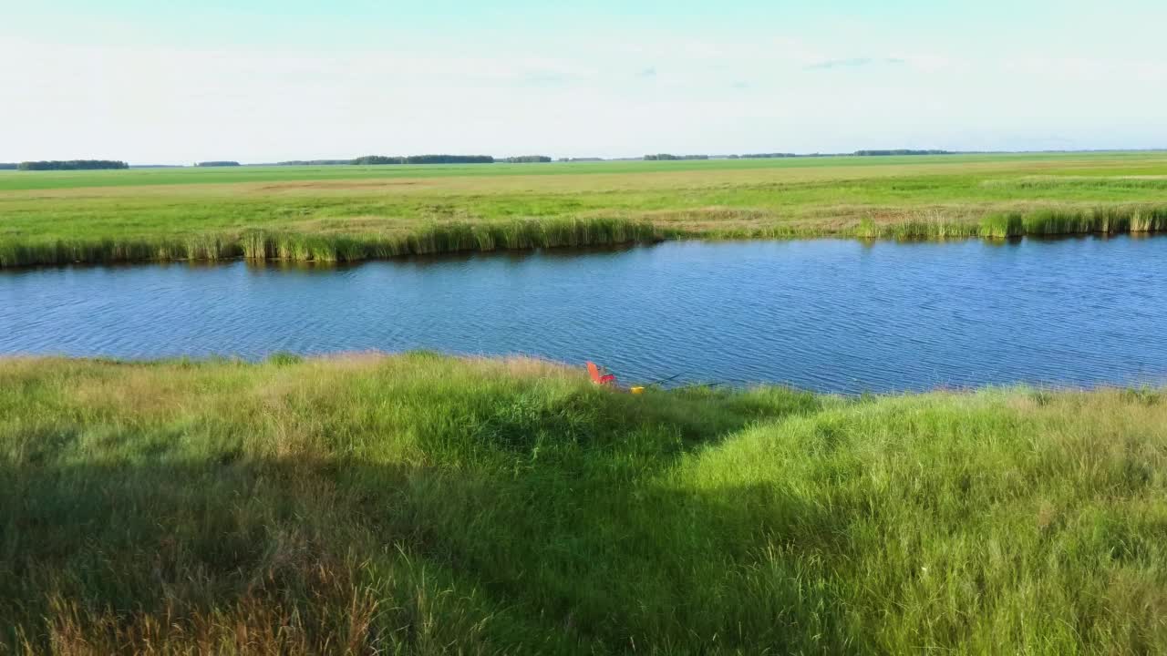 河流空中景观电影无人机镜头。在河流上空飞过绿色的田野视频素材