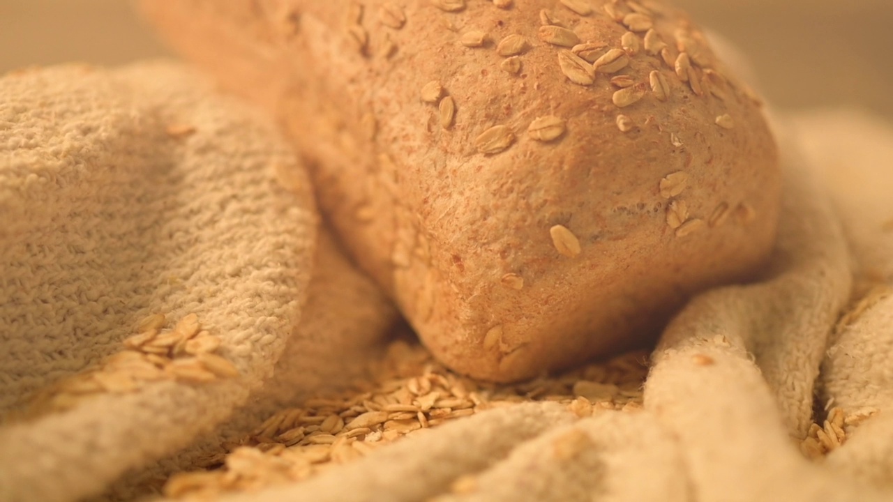 高清特写镜头，一条面包上覆盖着粗麻布上的谷物种子视频下载