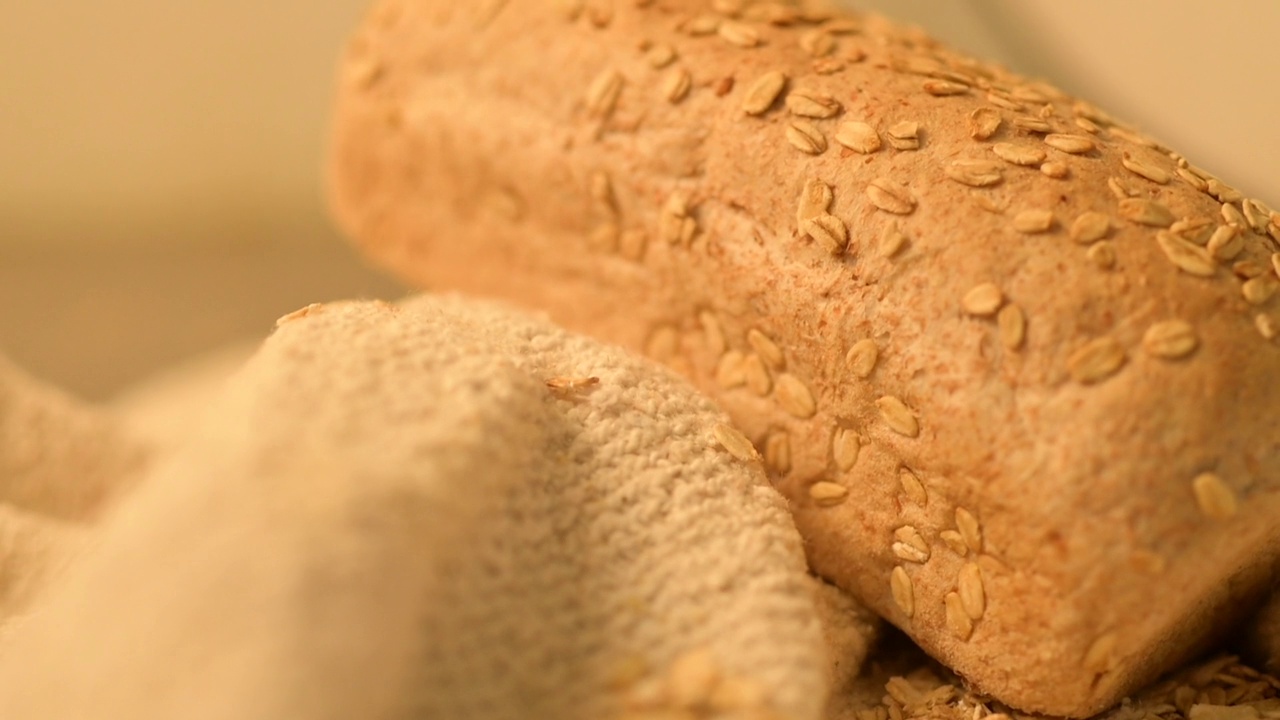 高清特写镜头，一条面包上覆盖着粗麻布上的谷物种子视频下载
