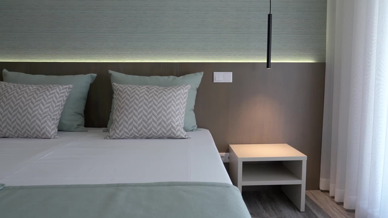现代极简主义卧室的放松和睡眠。摆放在床头柜上的极简灯具。视频素材