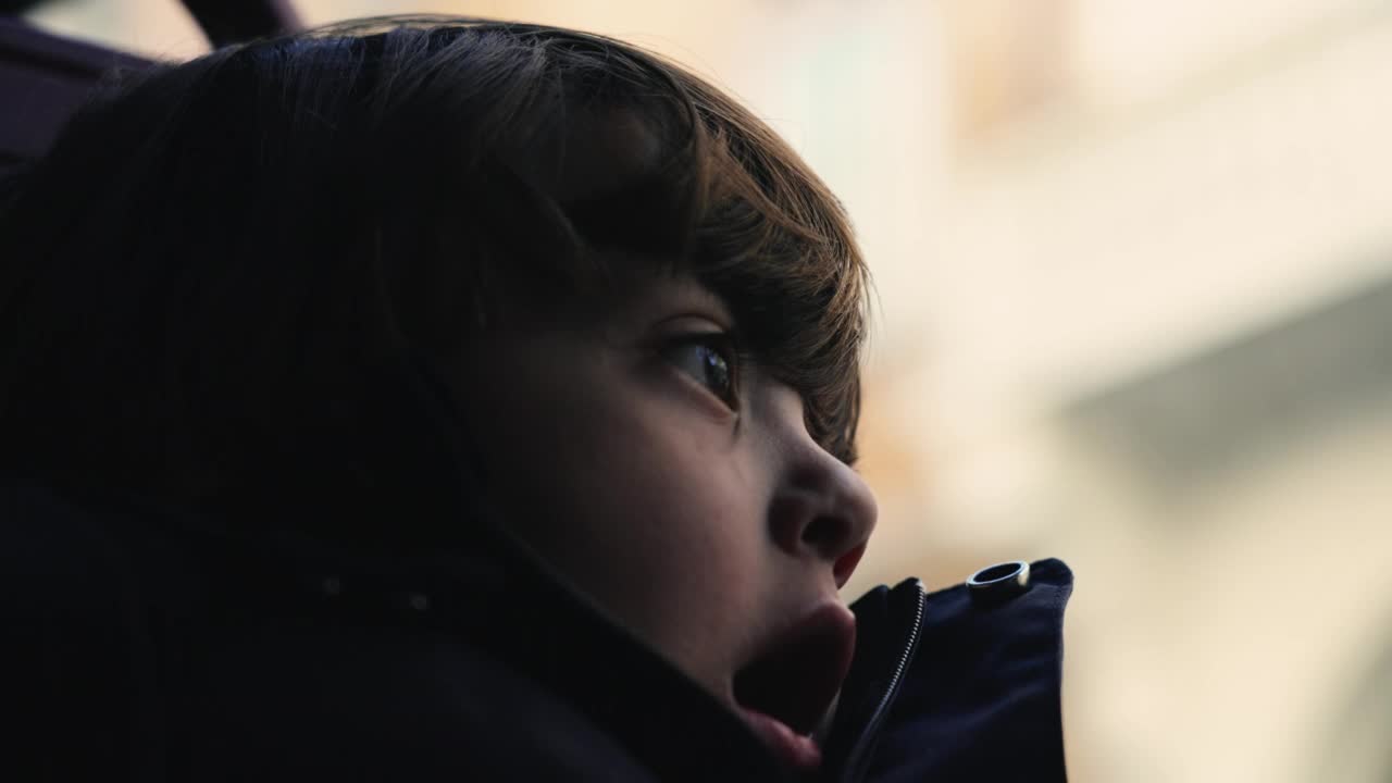 一个深思熟虑的小男孩的肖像特写脸。陷入沉思的沉思的孩子视频素材