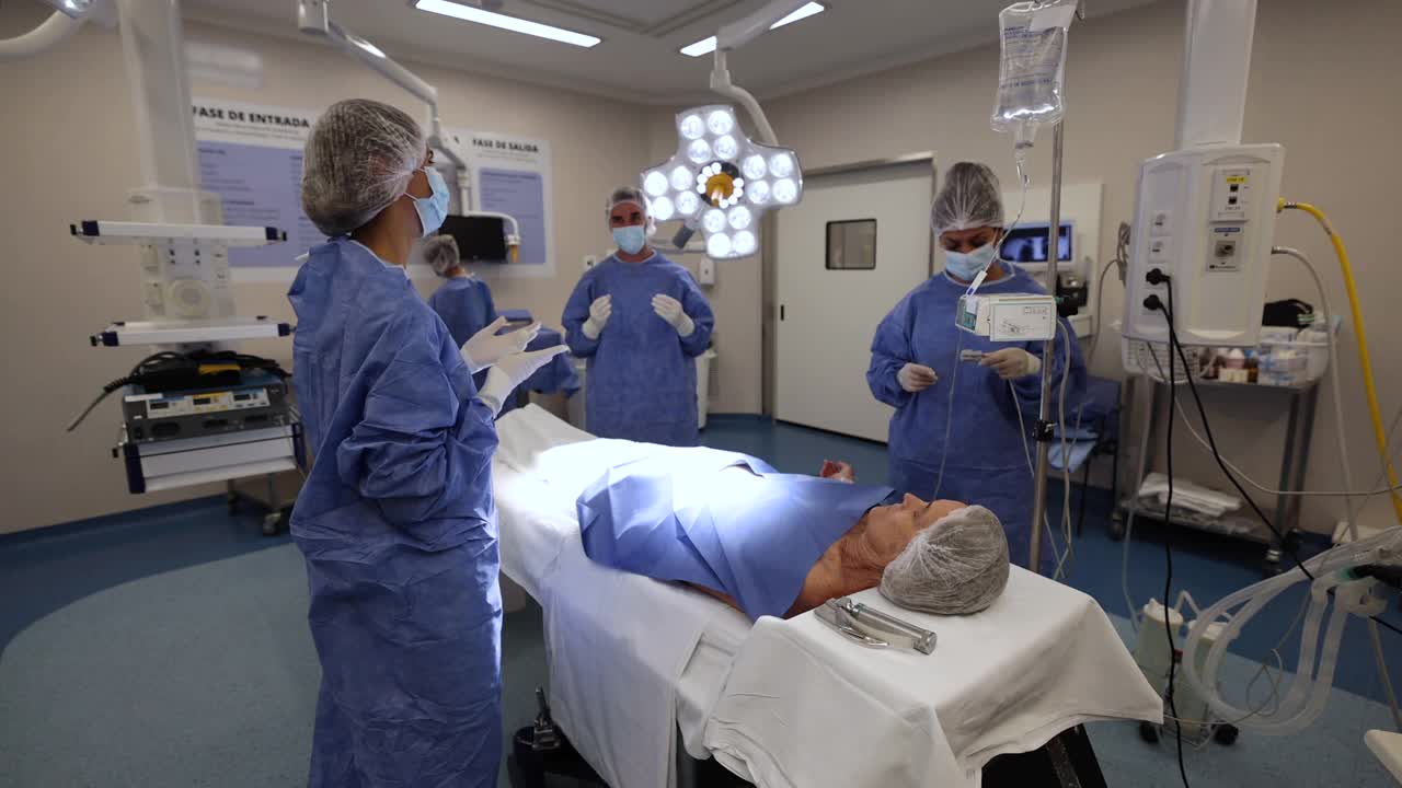 当外科医生在手术室里等候病人时，女护士正在为一位高龄病人做手术准备视频素材