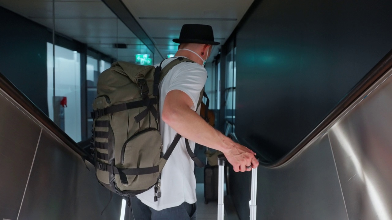 一个背着背包的男人到达扶梯底部的后景视频下载