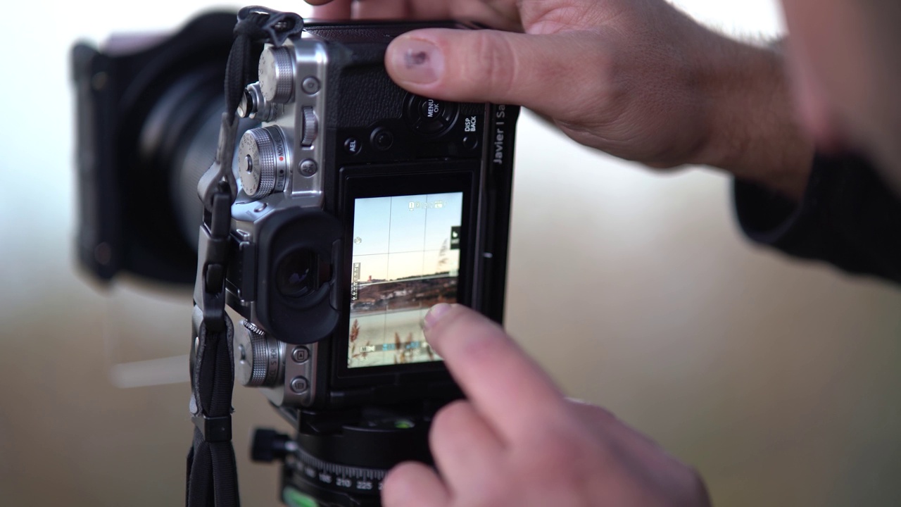 一名男子正在安装专业相机的工具，以捕捉秋天的日落和湖景视频下载