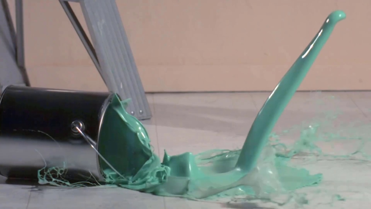 浅绿色的油彩从罐子里倾泻而出。掉落的油漆可以储存视频。视频素材