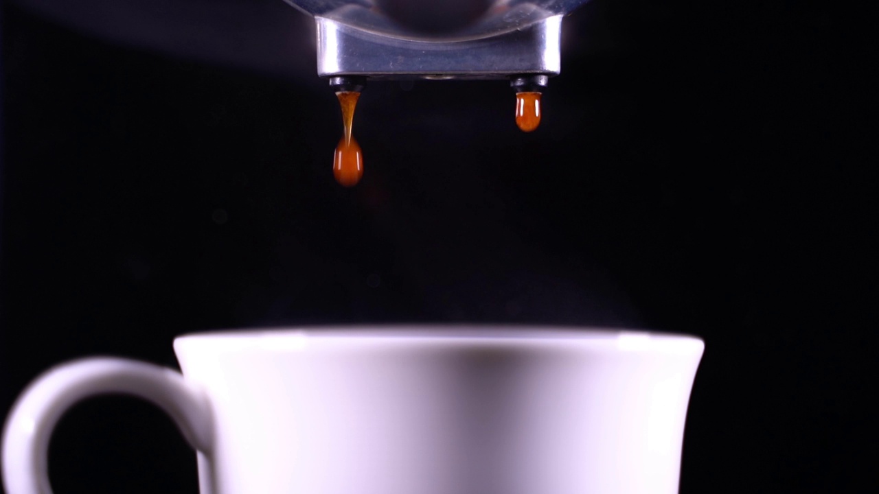 咖啡泡沫特写。浓缩咖啡从全自动咖啡机里出来，把咖啡机变成杯子。软的焦点。视频素材