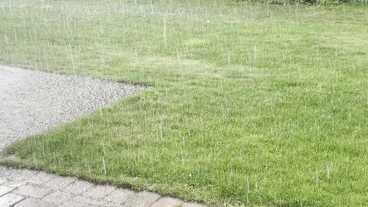 雨水落在草坪和混凝土车道上的风景视频素材