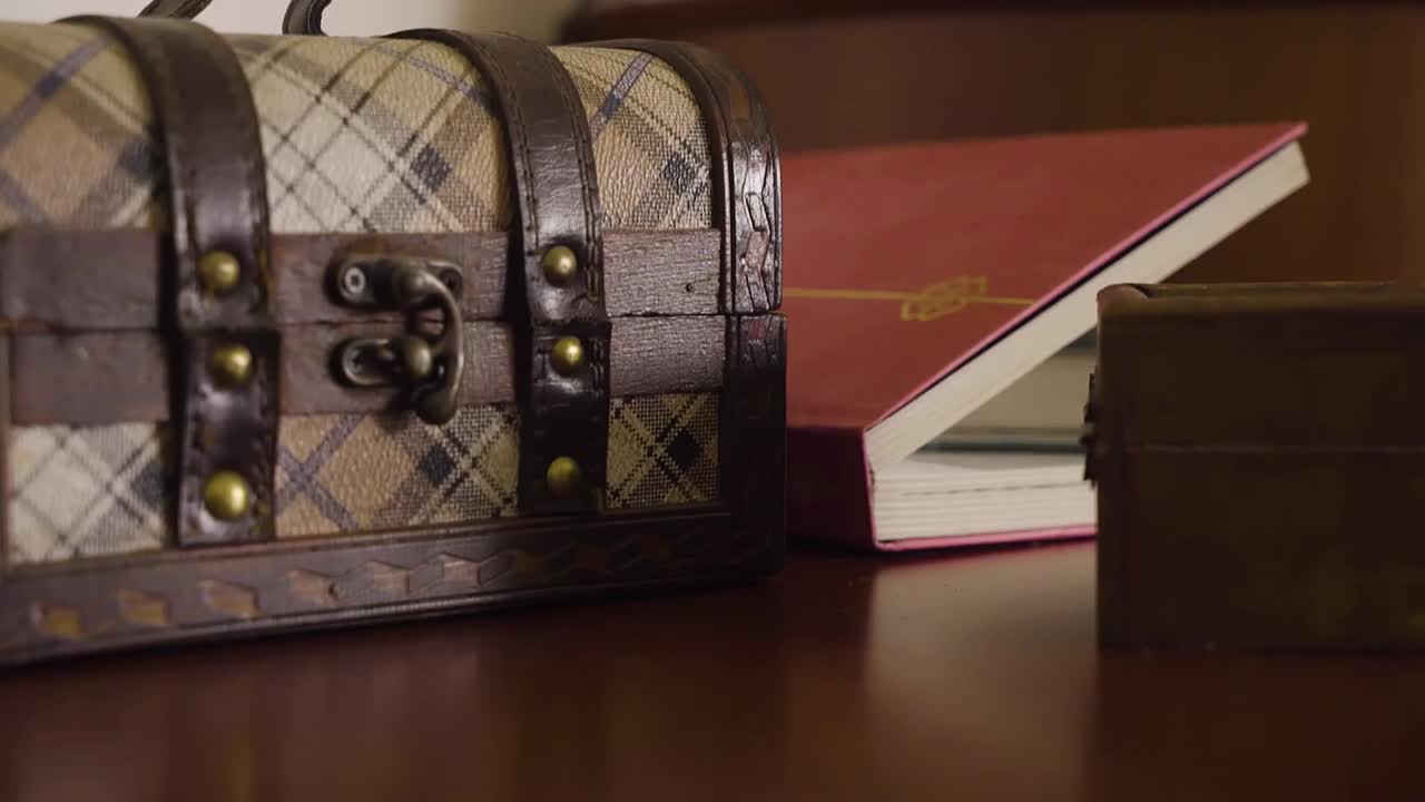 小棕色箱子和一个红色笔记本在桌子上视频下载