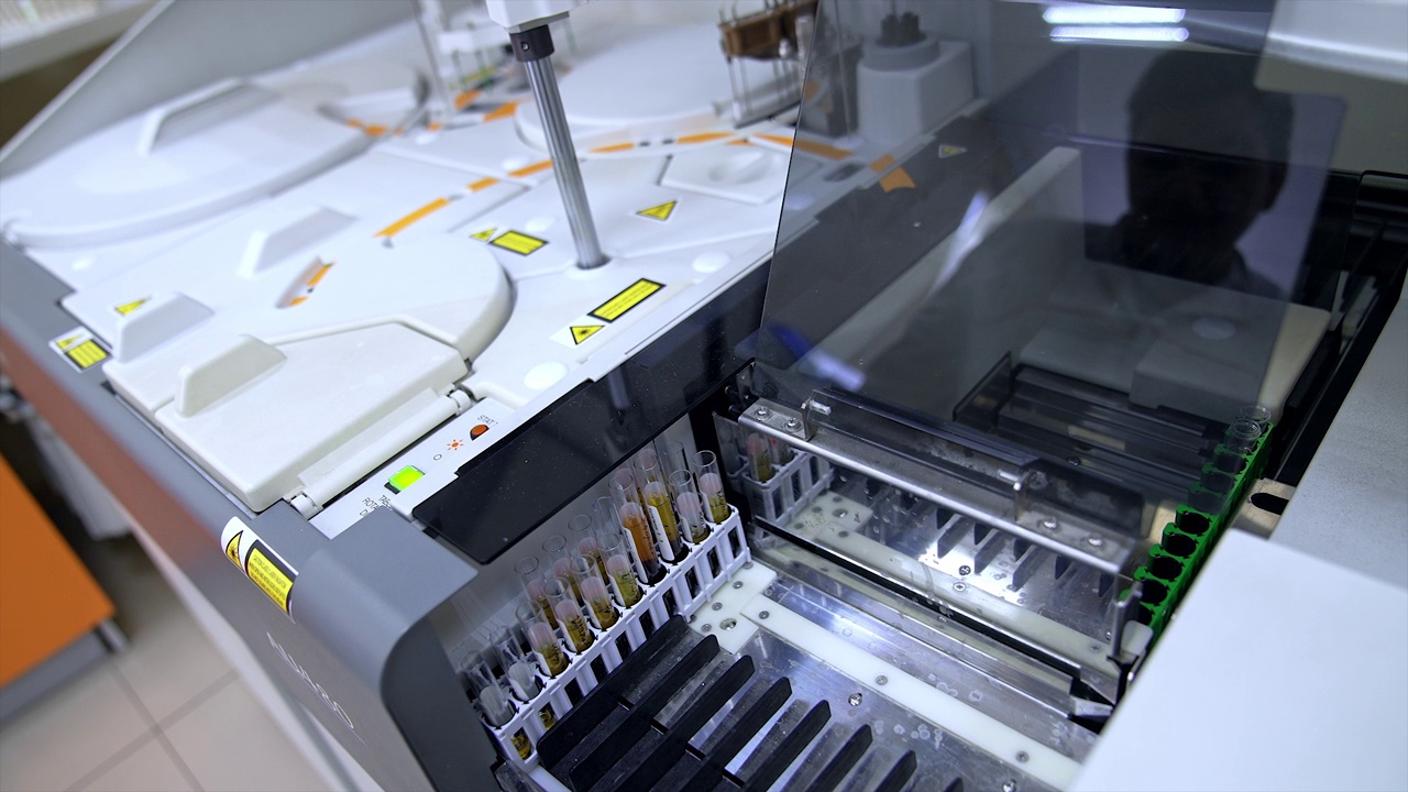 医院化验室配备现代化先进的血液科学检测设备。测试玻璃在机器内部移动。视频下载