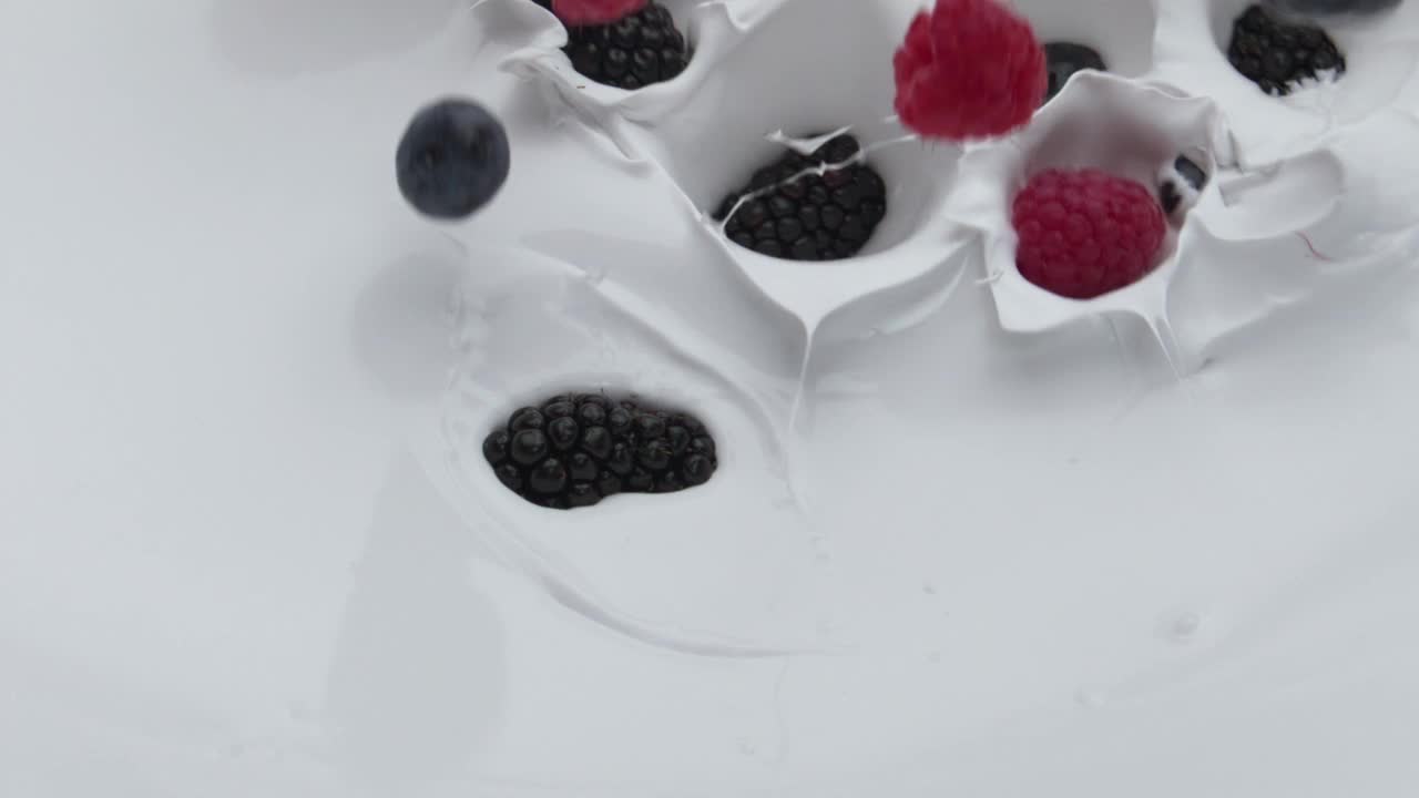 美味的浆果掉落酸奶的超慢镜头特写。健康维生素食品视频素材