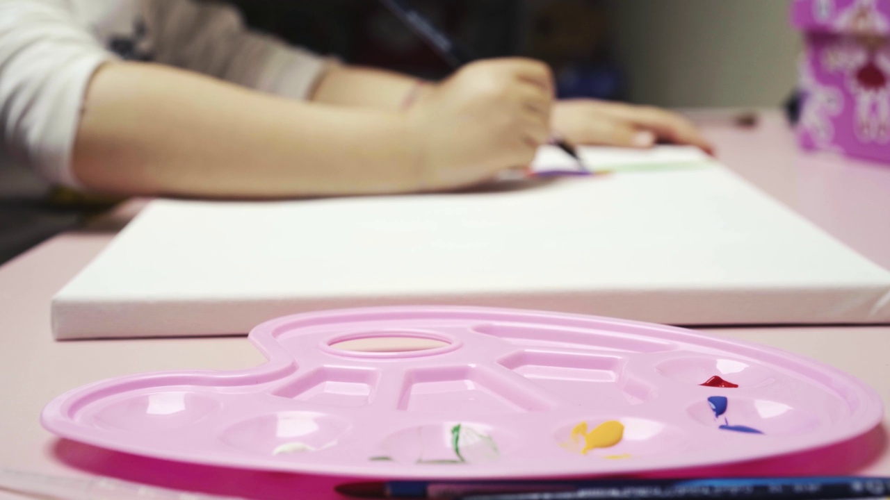 接近的孩子女孩绘画与粉红色调色板4k水彩画视频素材