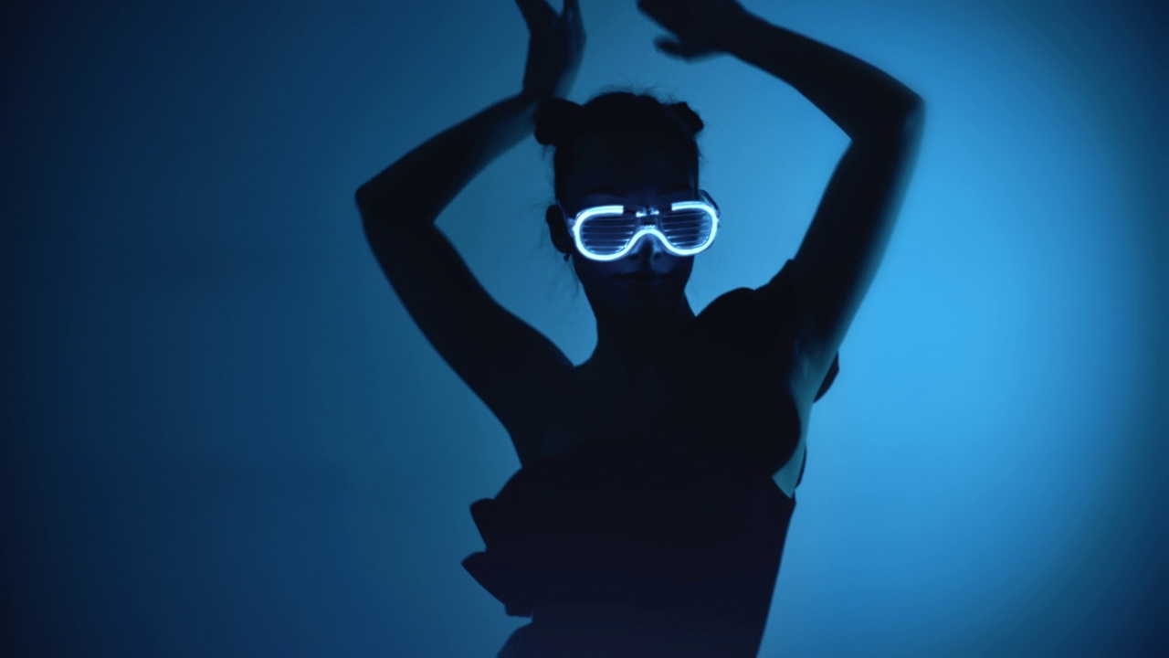时尚迪斯科女子在闪光霓虹灯眼镜表演舞蹈动作视频素材